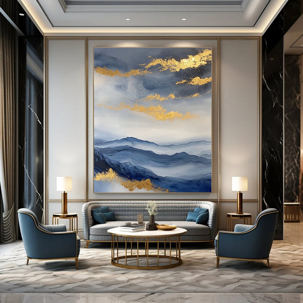 Large abstract painting featuring a beautiful sky mountains and clouds in blue and gray with gold foil accents.STSC279