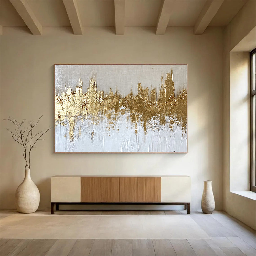 Large abstract painting of a gold and white cityscape with textured canvas and gold foil accents on a neutral background.SC173