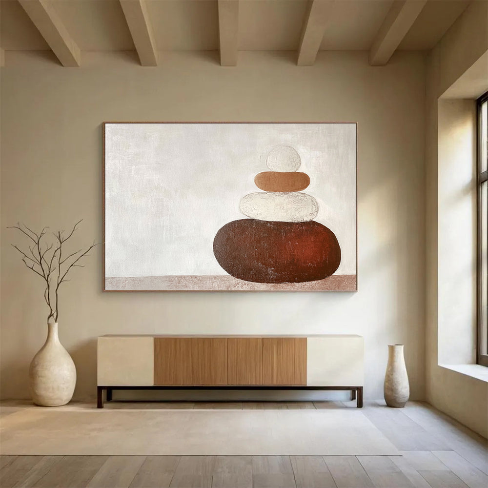 Large abstract painting in earth tones featuring three stacked rocks against a white background creating an elegant contrast.SC495