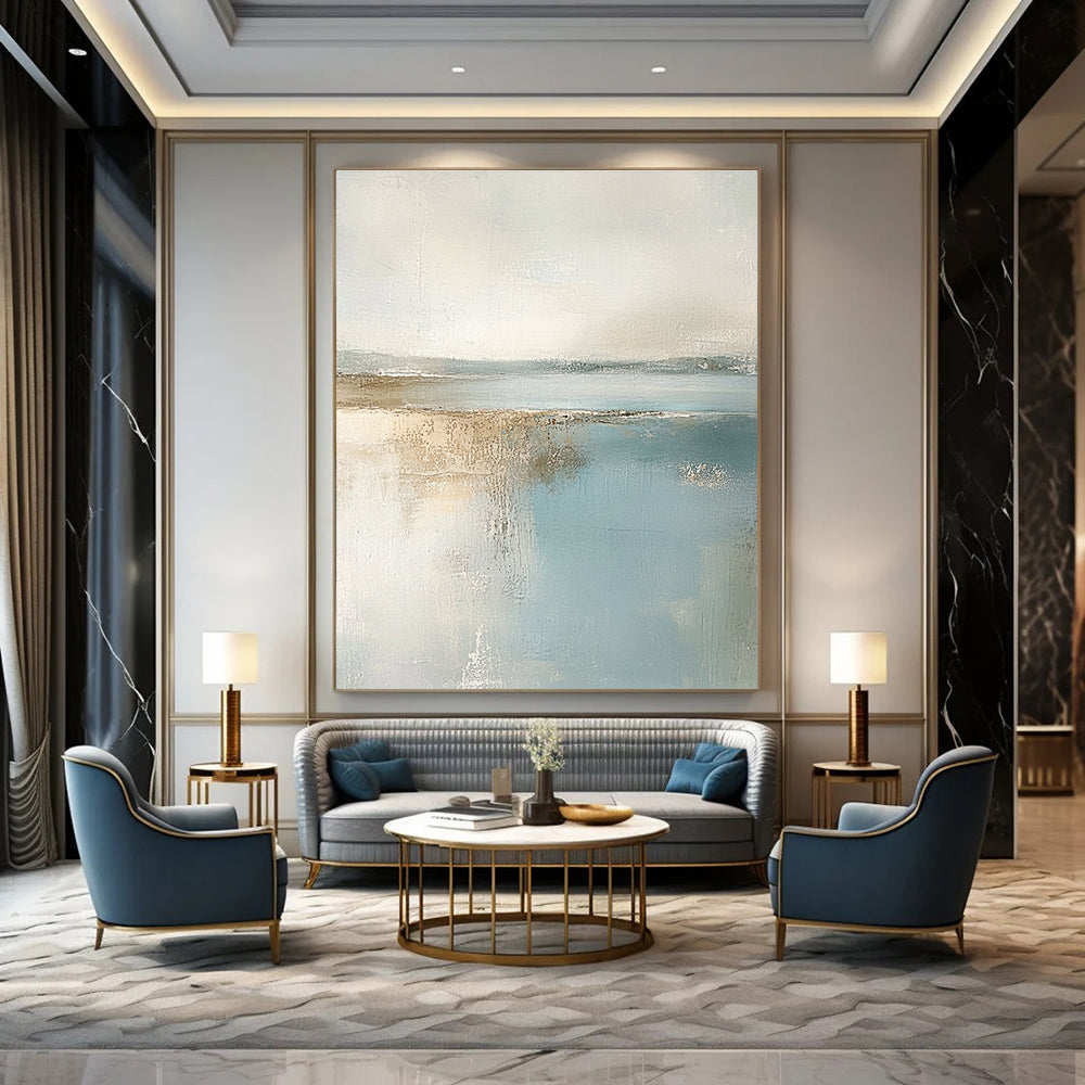 Large abstract painting featuring muted pastel colors of beige and light blue creating a calming beach landscape in neutral tones.STSC017