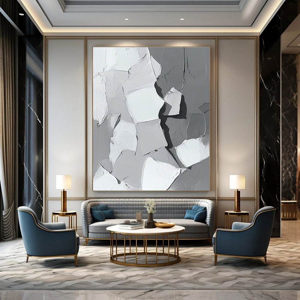 Large abstract painting in gray and white showcasing body parts in armor with bold brush strokes and thick paint application in a striking monochrome palette.STSC479