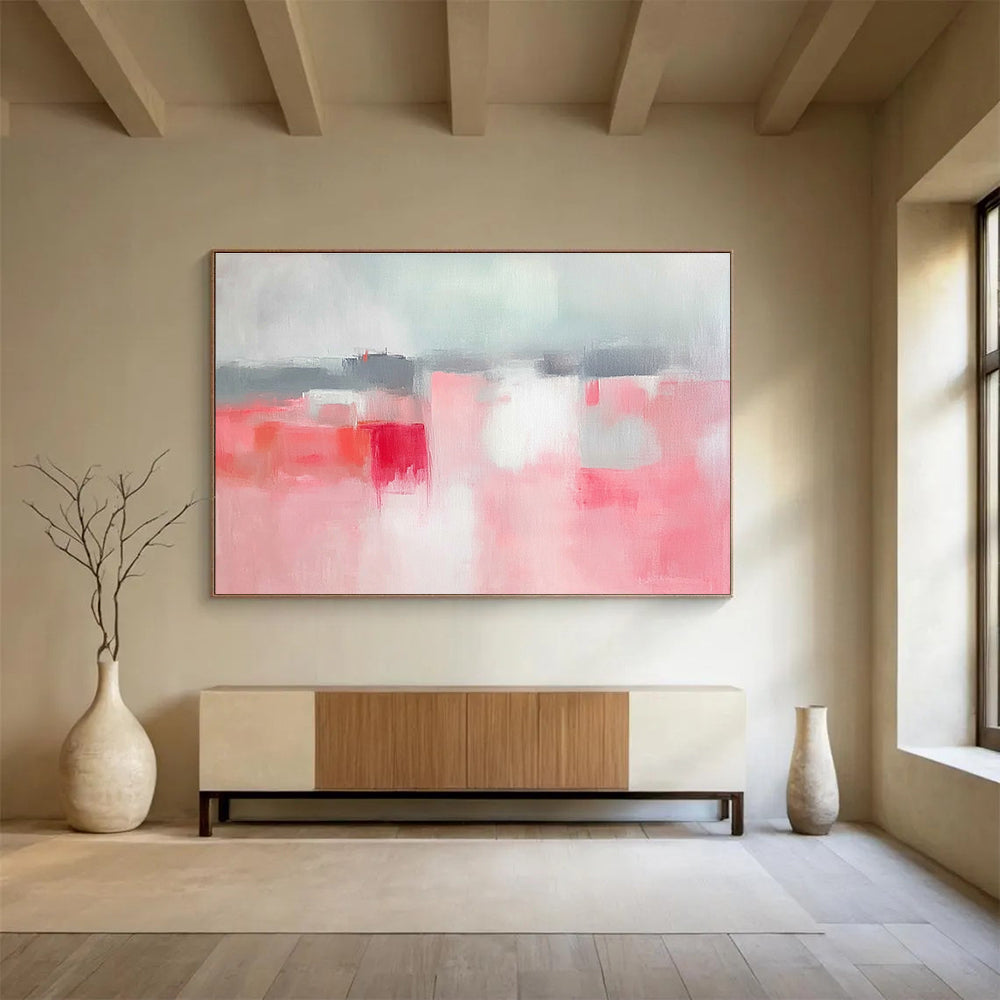 Large abstract painting featuring soft pink and grey tones, white space, sky blue, red accents, and a blurred town background.SC257