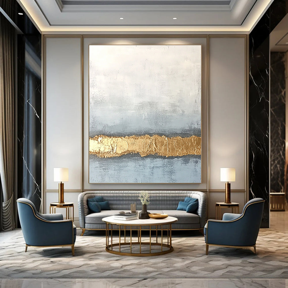 Large abstract painting with textured surface in soft gray and pale blue featuring a golden glitter line at the bottom.STSC735