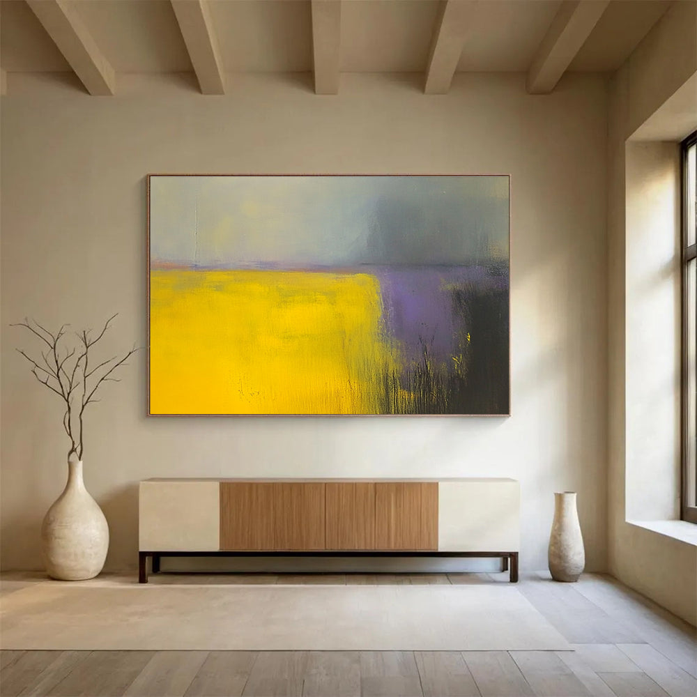 A large abstract painting featuring vibrant yellow and gray fields with subtle purple hues, enhanced by dynamic brushstrokes and a blurred background.SC475