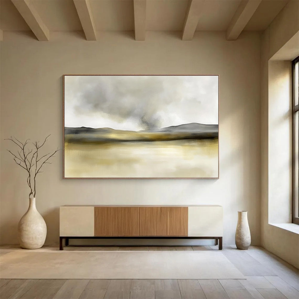 Large abstract painting in soft watercolors featuring neutral beige and gray tones with yellow accents and distant rolling hills under smoke.SC075