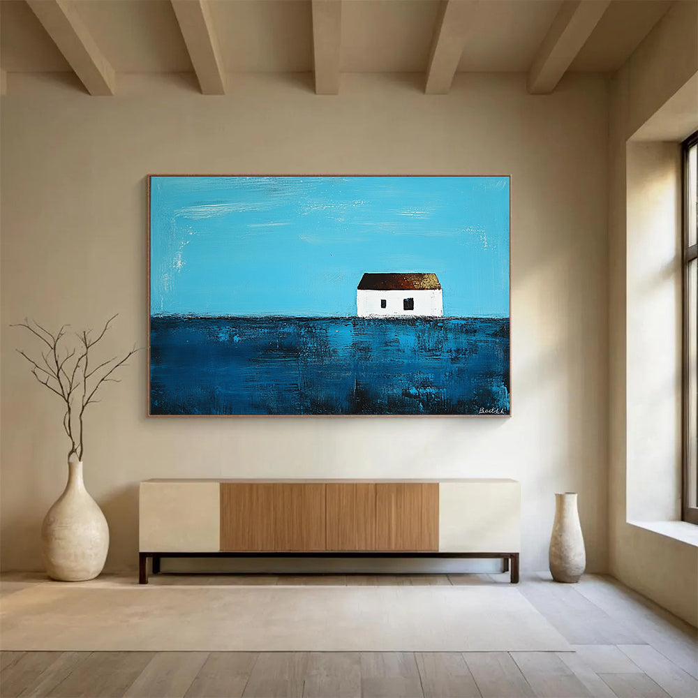 A large abstract painting featuring a small white house on the horizon surrounded by deep blue sea in the style of Anna Bocek.SC553