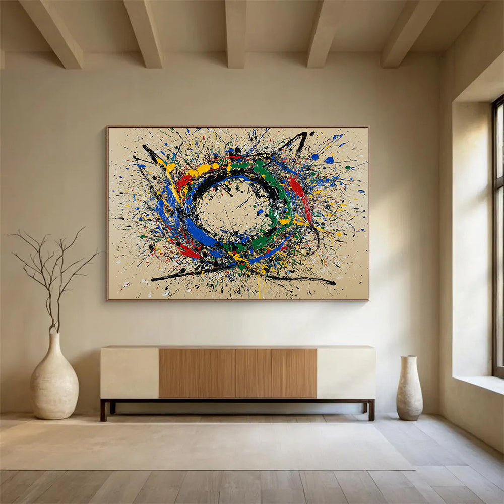 A large abstract painting featuring a circular splash pattern in blue red green yellow and black on a beige background.SC331