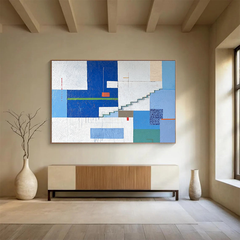 A large abstract painting of an urban landscape in blue and white tones, featuring geometric buildings with green accents, stairs, windows, and doors.SC488