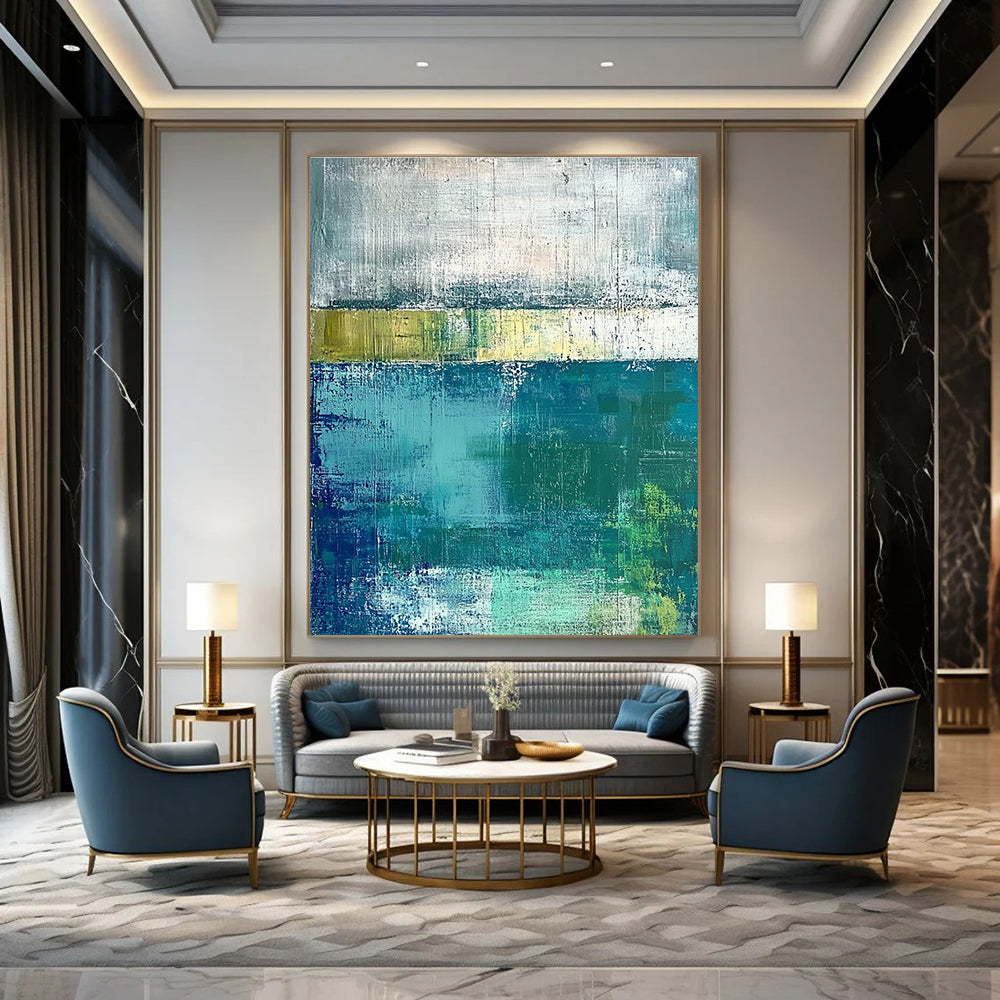 Large abstract painting with green and blue tones on a gray background evokes a serene water's edge mood with textured surfaces.STSC420