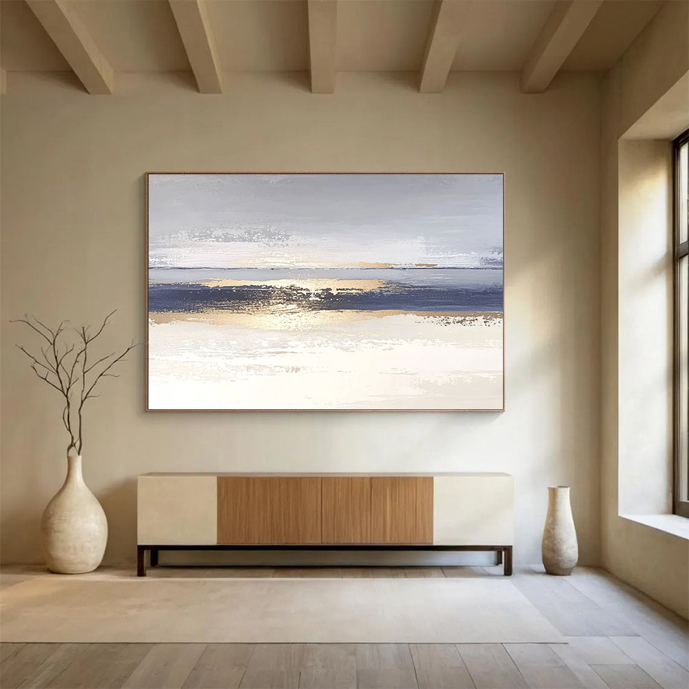 Large abstract painting with soft light blue and gray tones featuring metallic gold lines depicting water ripples on serene sand.SC007