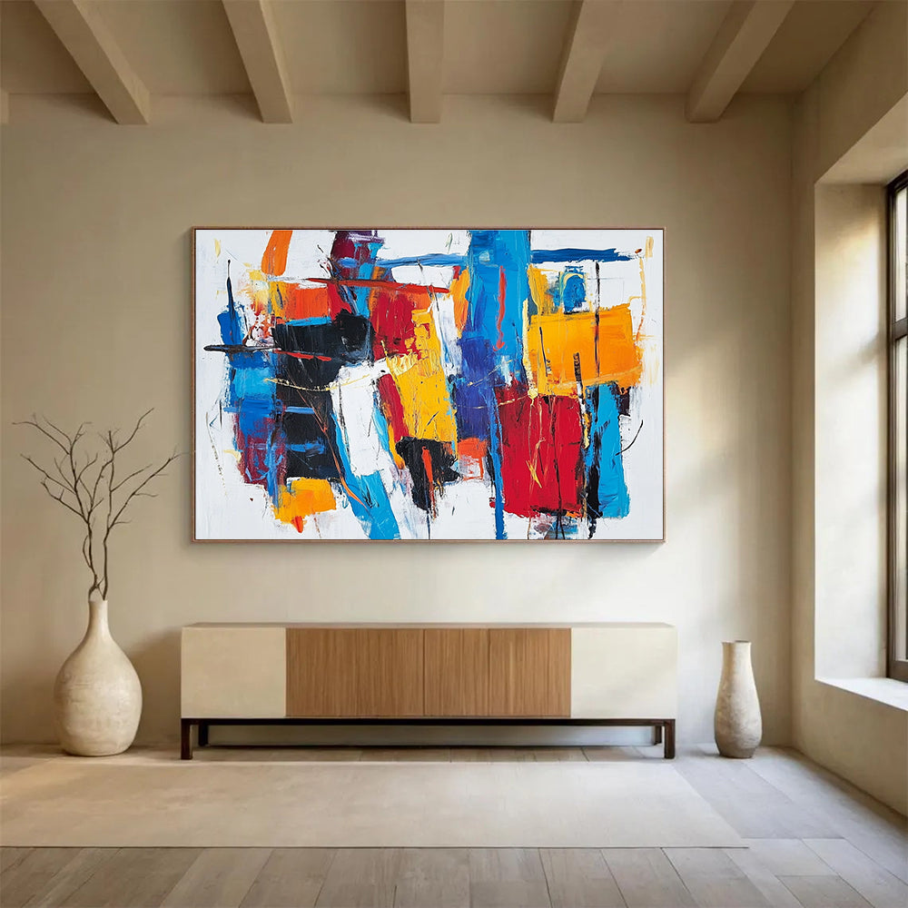 Large abstract painting with thick brush strokes and vibrant reds blues and yellows creating a unique abstract cityscape on a white background.SC262
