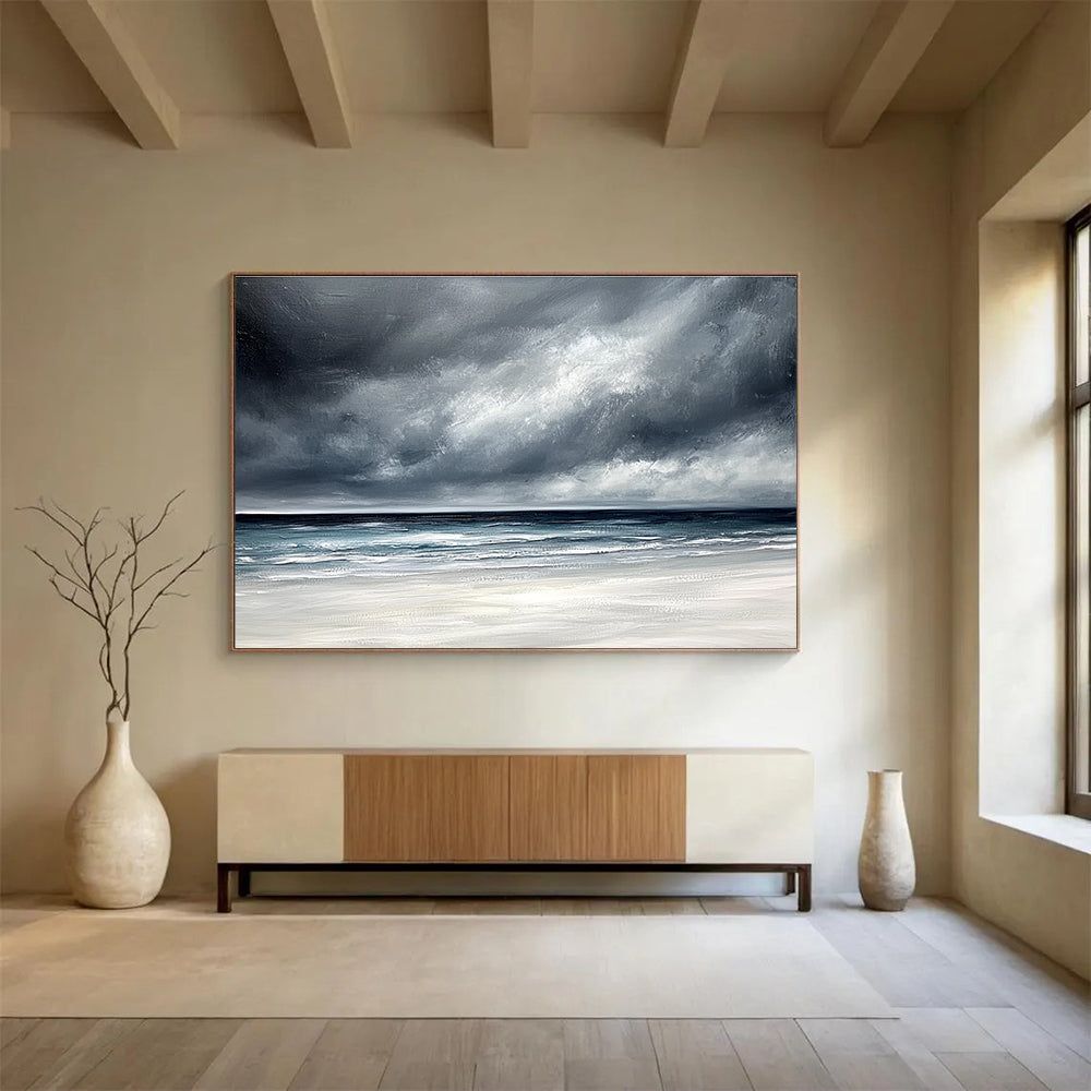 Large abstract painting featuring an ocean with stormy gray clouds and a white sand beach in soft gray and blue tones.SC163