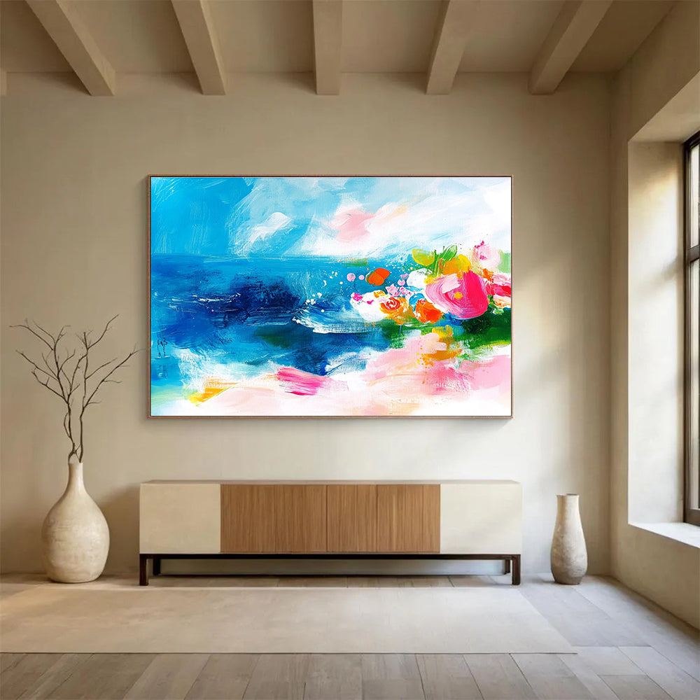 Large abstract painting of the ocean featuring bold brush strokes in pink blue green and orange with small flowers on a textured white background.SC363