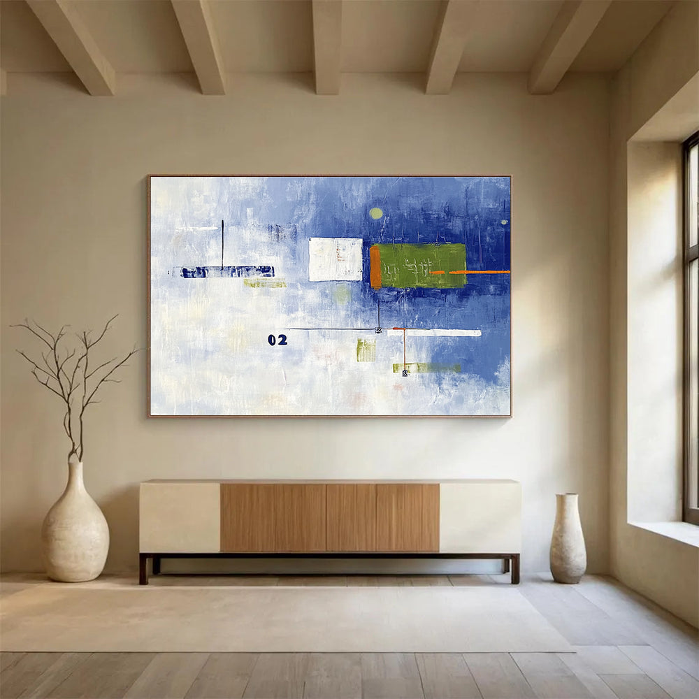 A large abstract painting with broad brush strokes in cool blue and white, featuring bold geometric shapes in green and orange, creating depth and contrast.SC493