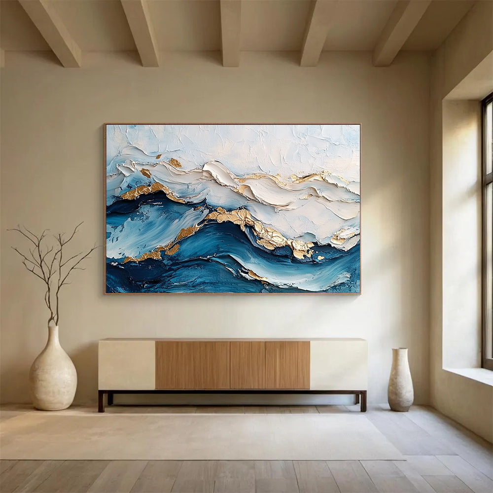 Large abstract painting featuring ocean waves in textured white and blue hues with gold accents for depth and elegance.SC102