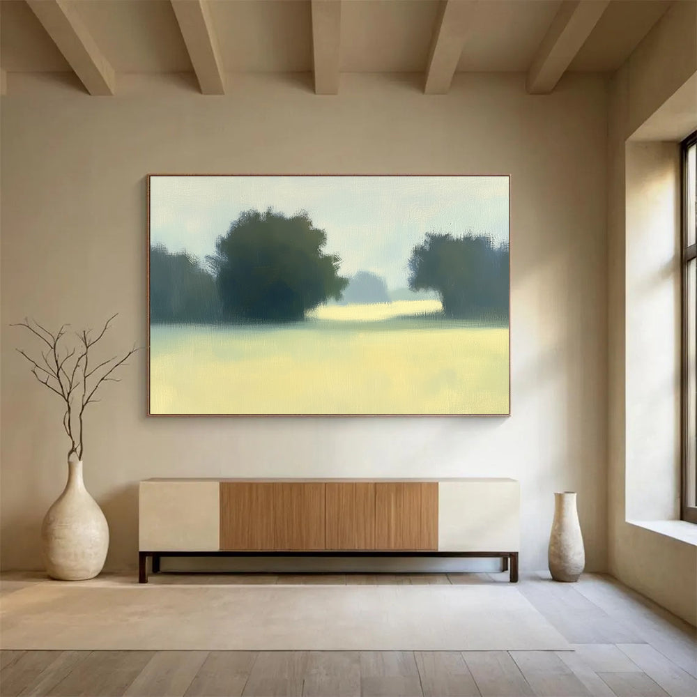 A large abstract painting featuring impasto technique with soft hues of green and yellow depicting a hazy field with distant trees.SC498