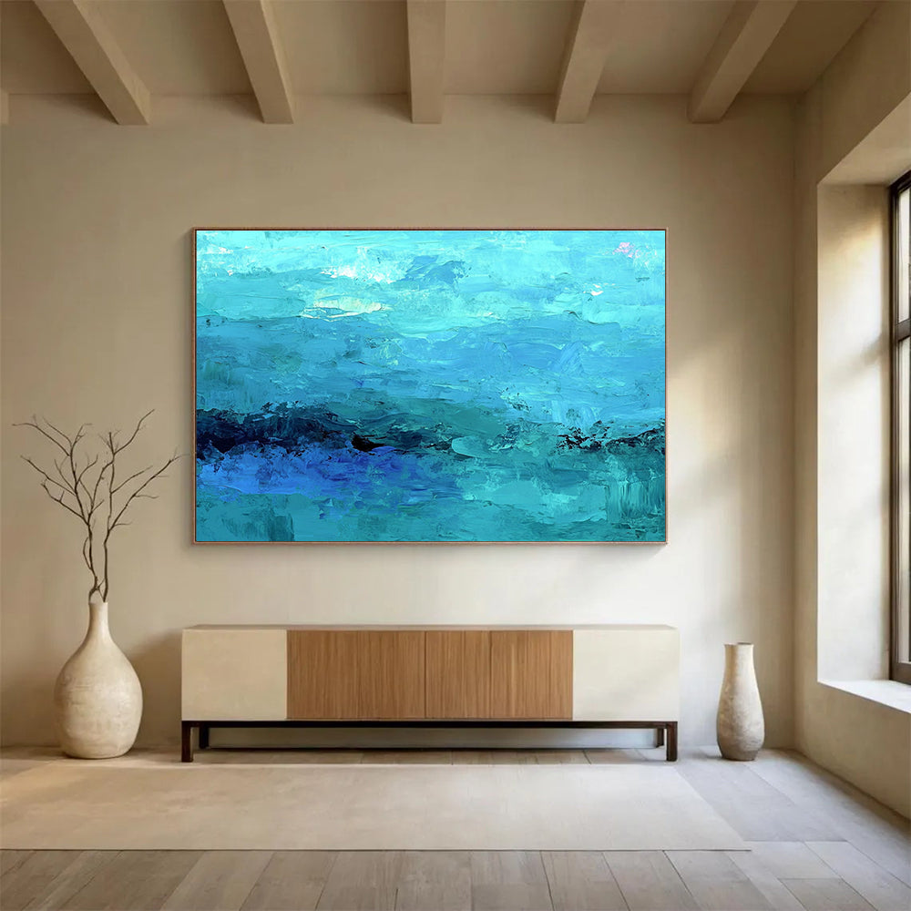 Large abstract painting of the ocean in soft blues and teals showcasing impressionistic waves and a mysterious silhouette beneath gentle mist.SC201