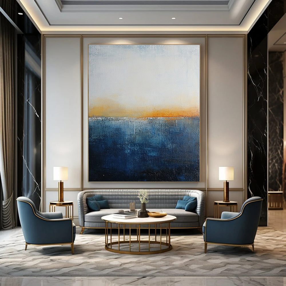 Large abstract painting with layered blue and yellow textures evokes oceanic depths at dusk with soft lighting enhancing movement and depth.STSC109