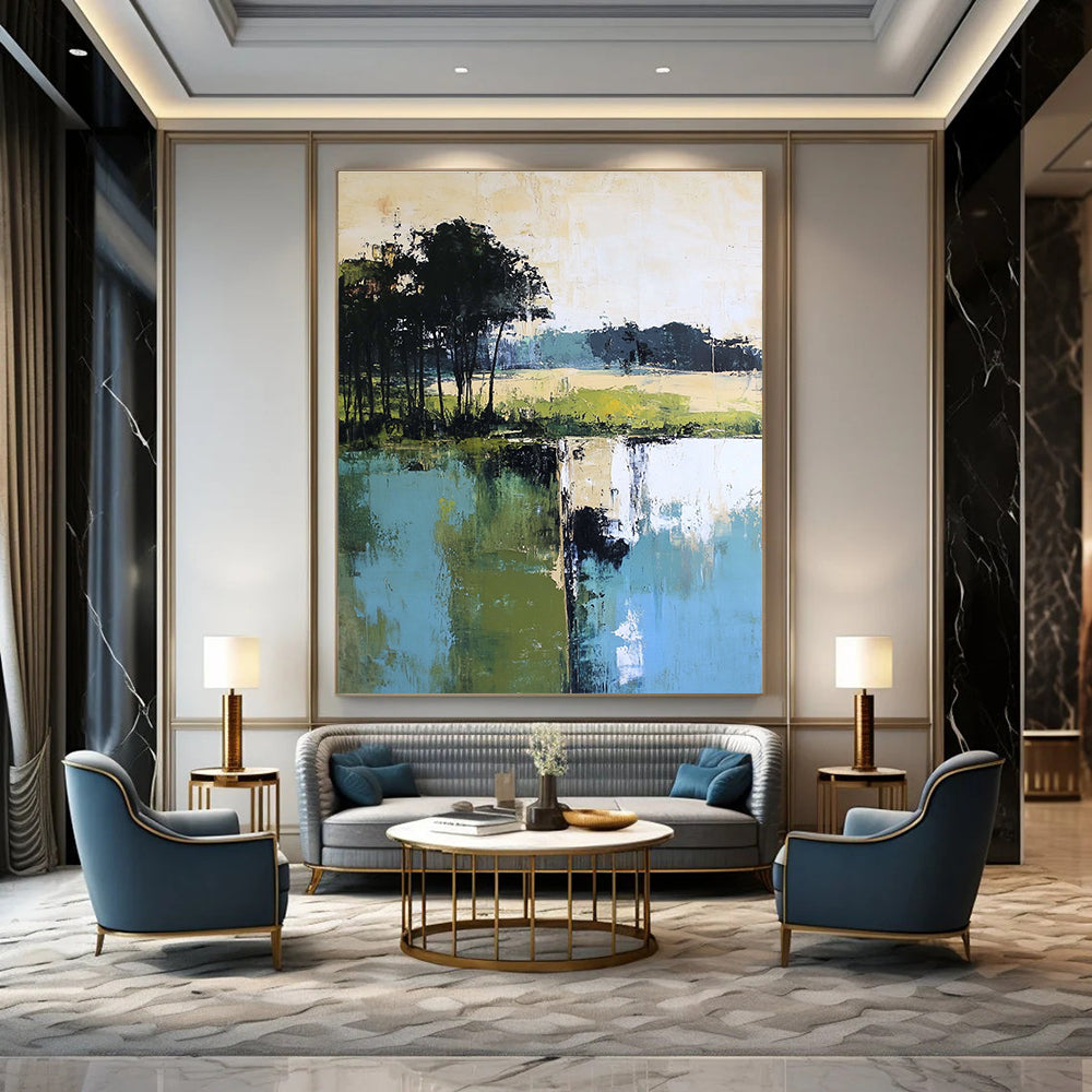 Large abstract painting featuring green blue and beige hues with distant trees foreground trees and green grass by the water.STSC098