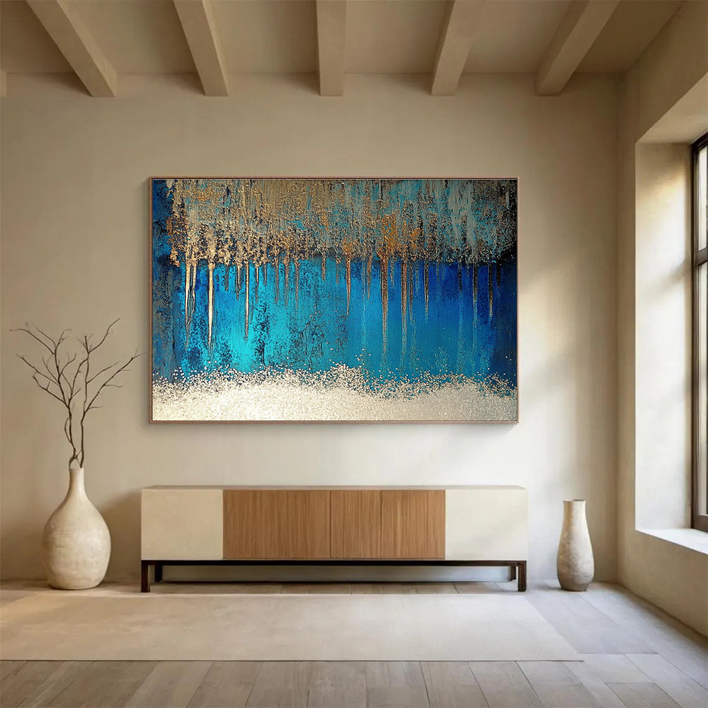 A large abstract painting featuring blue and silver patterns with glittering white sand and a rich brown liquid, accented by a thin silver line.SC346
