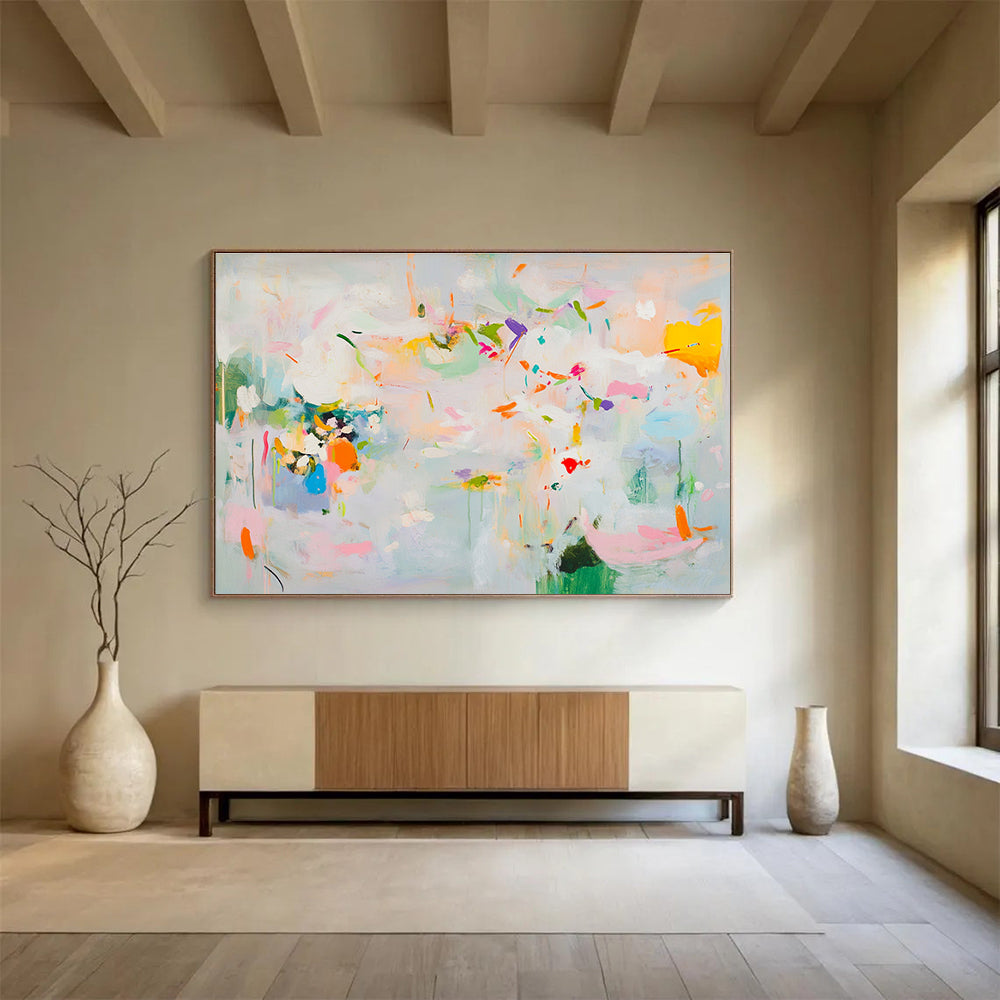 Large abstract painting in soft pastels featuring spring themes with flowers leaves trees and vibrant splashes of color creating a lively atmosphere.SC384