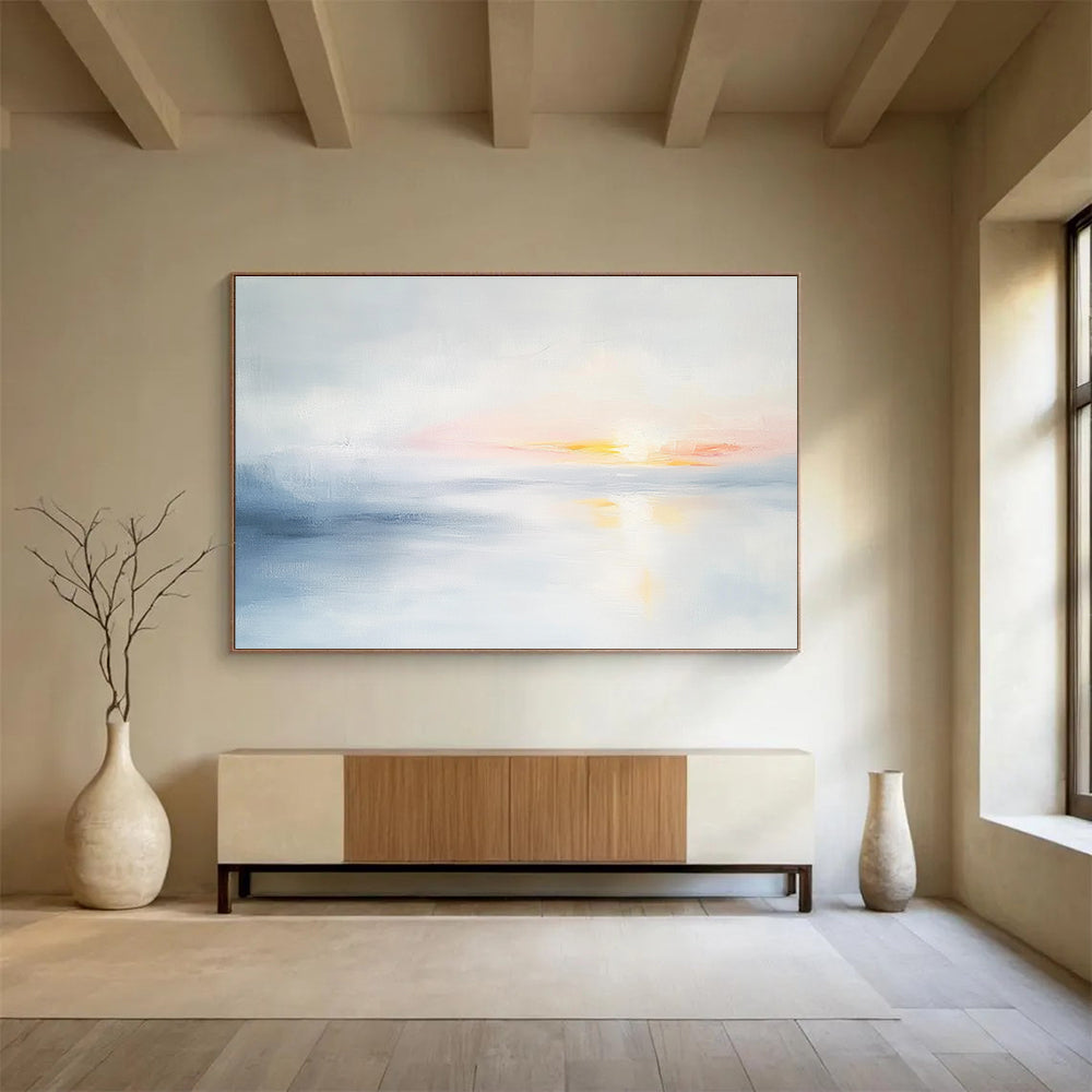 Large abstract painting featuring soft light sky blue and gray tones depicting a serene sunset over calm water on a white background.SC082