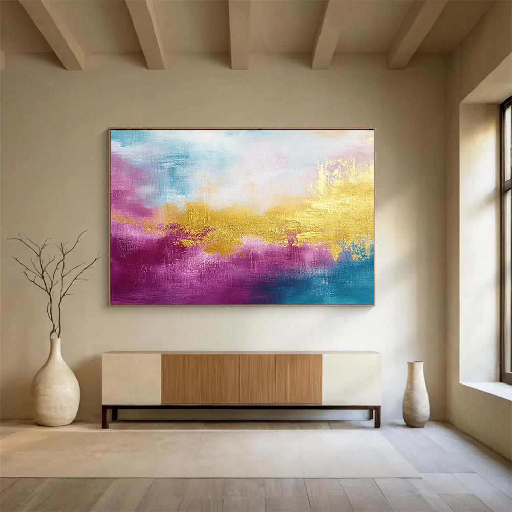 A large abstract painting features gold, magenta, and cyan hues with soft brush strokes and a tranquil water-inspired backdrop.SC322