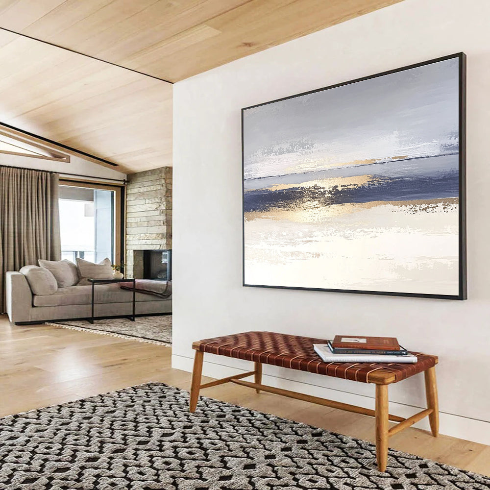 Large abstract painting with soft light blue and gray tones featuring metallic gold lines depicting water ripples on serene sand.SC007