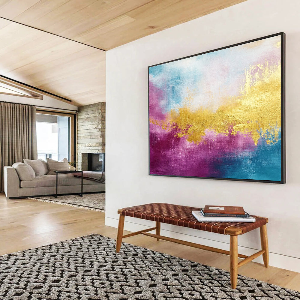 A large abstract painting features gold, magenta, and cyan hues with soft brush strokes and a tranquil water-inspired backdrop.SC322