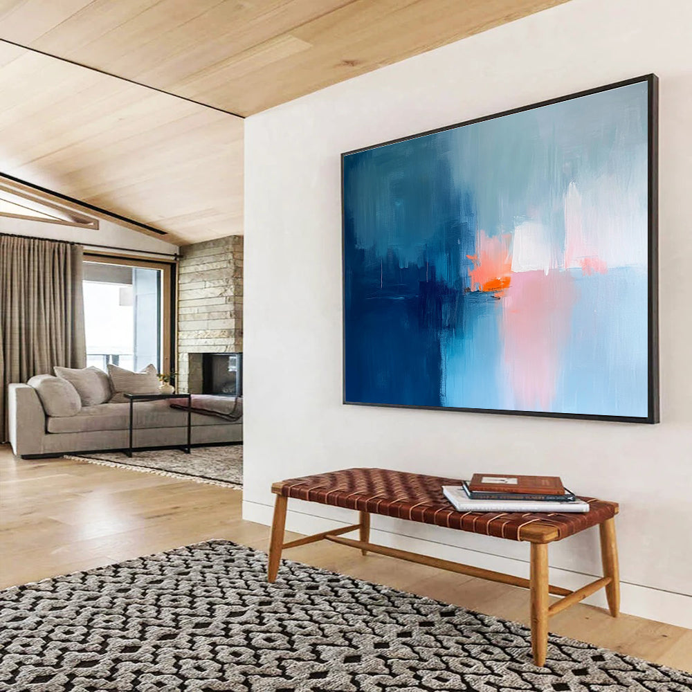 Large abstract painting in soft blue tones with pink and orange accents creates a serene mood through expressive brush strokes and blurred edges.SC253