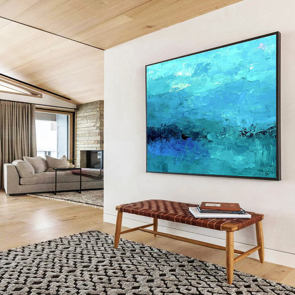 Large abstract painting of the ocean in soft blues and teals showcasing impressionistic waves and a mysterious silhouette beneath gentle mist.SC201
