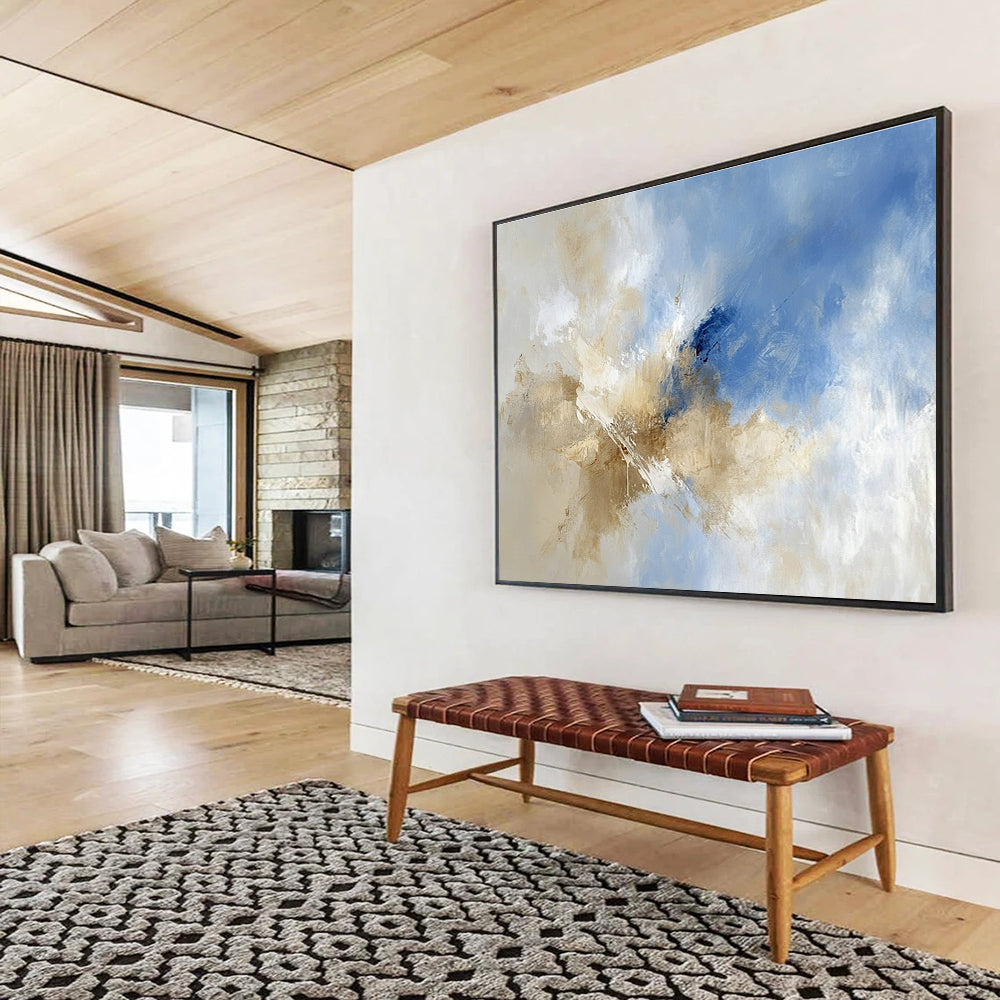 Large abstract painting featuring blue and beige hues with clouds in the sky, blending earthy tones of brown for a serene atmosphere.SC020
