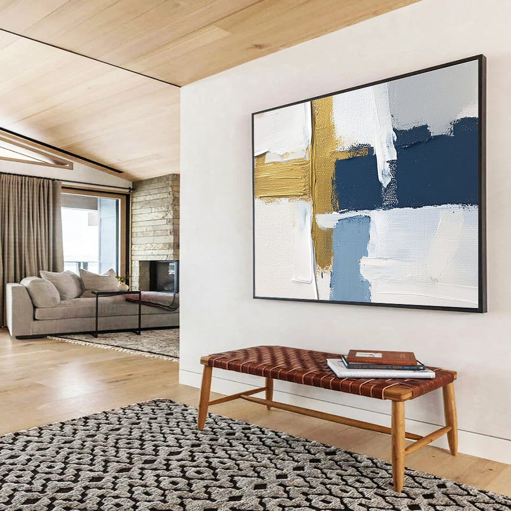Large abstract painting with white blue and gold blocks featuring brushstrokes and texture showcasing a golden cross for depth in a serene atmosphere.SC267