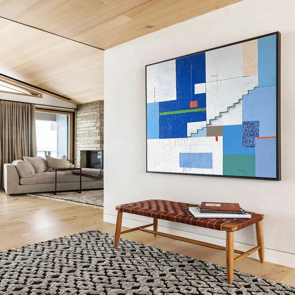 A large abstract painting of an urban landscape in blue and white tones, featuring geometric buildings with green accents, stairs, windows, and doors.SC488