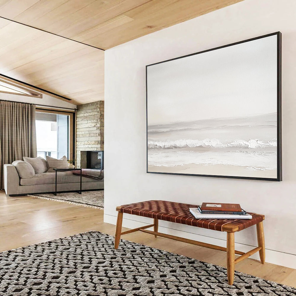 A large abstract painting of the sea featuring light gray and white tones with serene waves and a beige beach for added depth.SC502