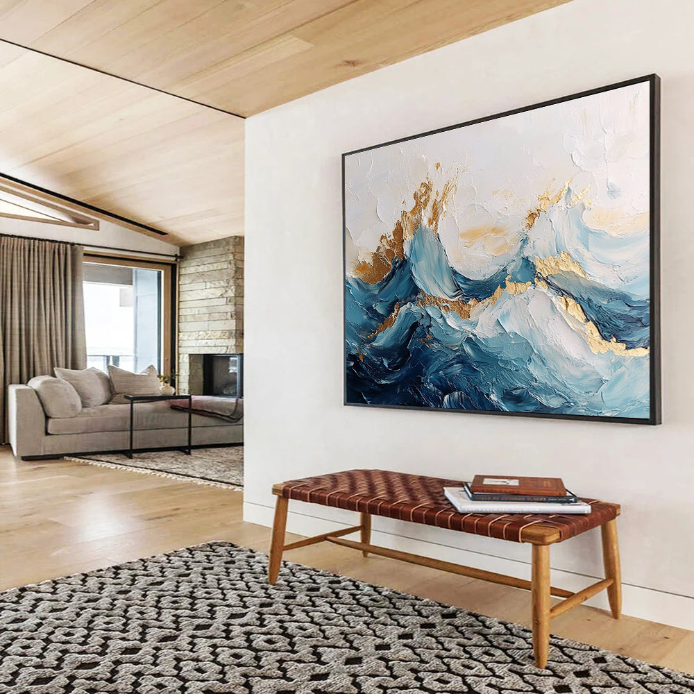 Large abstract painting of ocean waves in blue and white with gold accents featuring textured brush strokes and fluid shapes that convey movement.SC101