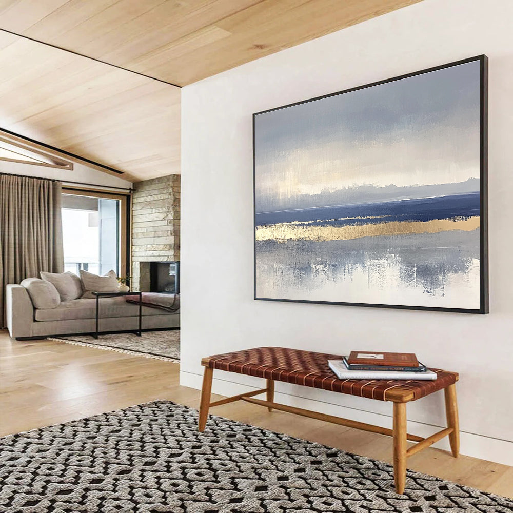 Large abstract painting featuring soft blue and gray tones with gold accents and visible brush strokes on a neutral background.SC038