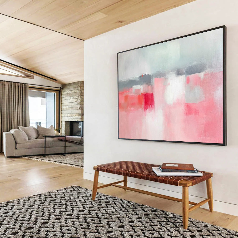 Large abstract painting featuring soft pink and grey tones, white space, sky blue, red accents, and a blurred town background.SC257