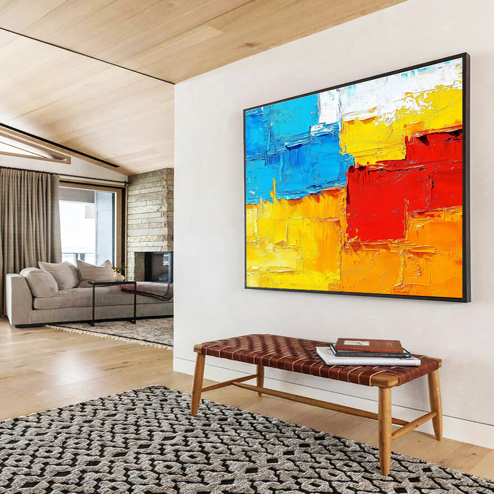 Large abstract painting featuring textured impasto brushstrokes in warm sunset tones of orange red yellow and blue.SC261