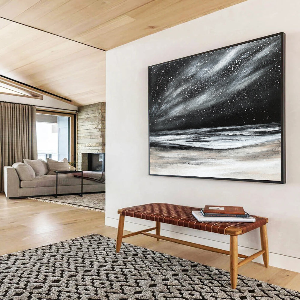 Large abstract painting depicting a dark stormy sky with stars and snow on the beach in black and white colors.SC295