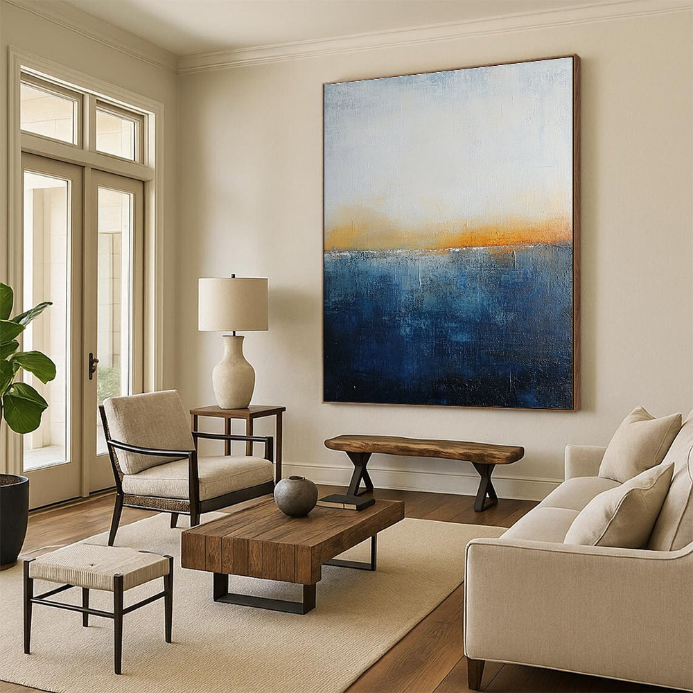 Large abstract painting with layered blue and yellow textures evokes oceanic depths at dusk with soft lighting enhancing movement and depth.STSC109