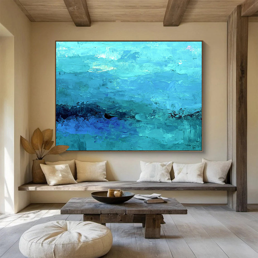 Large abstract painting of the ocean in soft blues and teals showcasing impressionistic waves and a mysterious silhouette beneath gentle mist.SC201