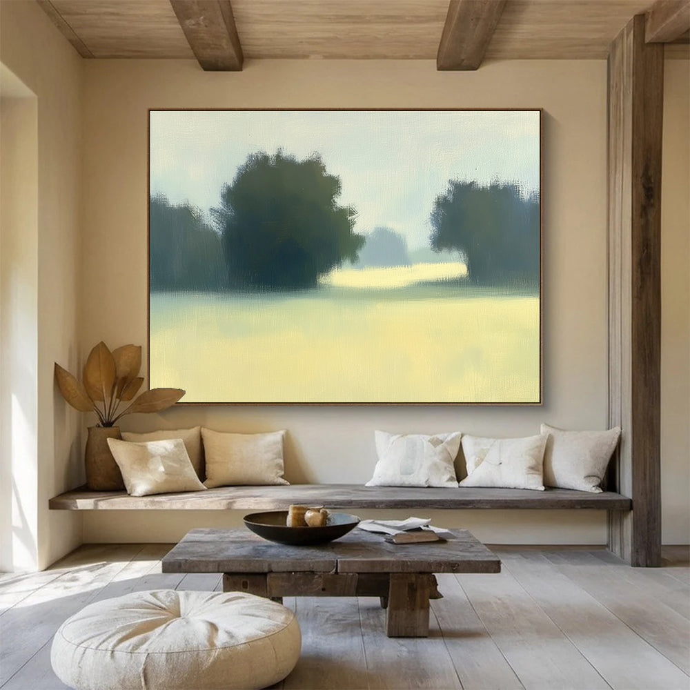 A large abstract painting featuring impasto technique with soft hues of green and yellow depicting a hazy field with distant trees.SC498