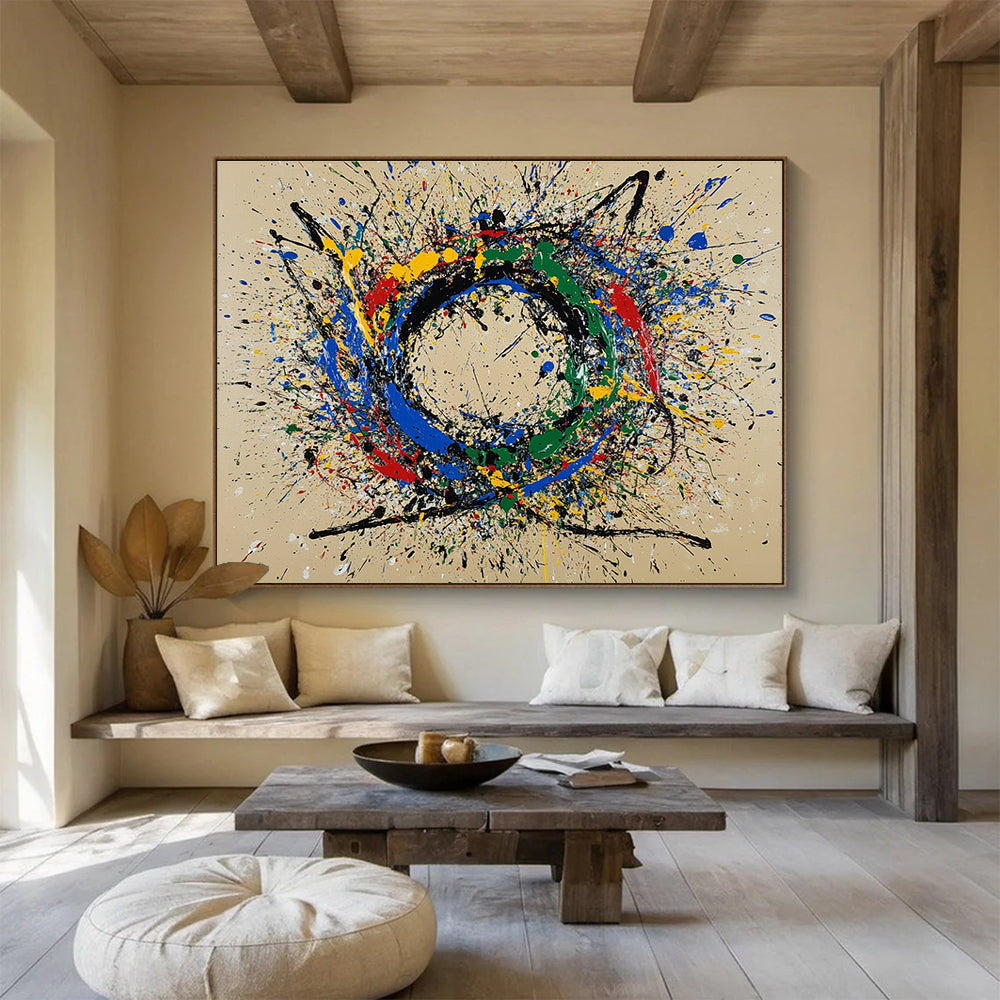 A large abstract painting featuring a circular splash pattern in blue red green yellow and black on a beige background.SC331