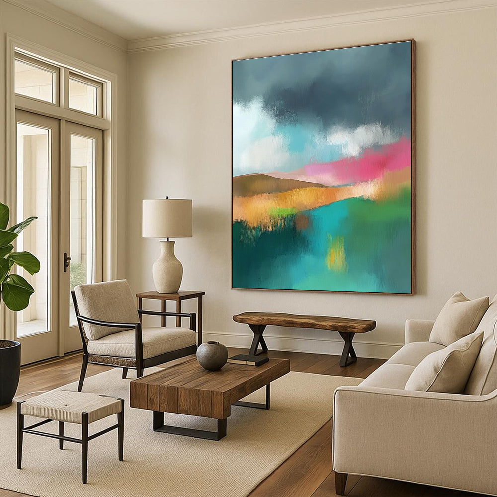 Large abstract painting featuring light teal and pink hues with a green field brown hills and a dark grey sky adorned with white clouds.STSC087