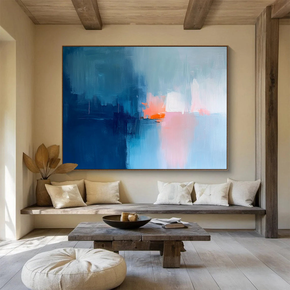 Large abstract painting in soft blue tones with pink and orange accents creates a serene mood through expressive brush strokes and blurred edges.SC253