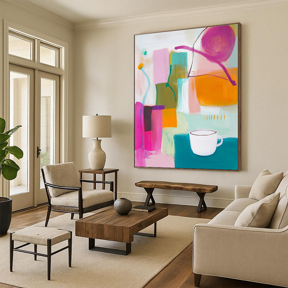 An abstract painting features vibrant pink green and yellow shapes with an orange object and a white cup on top alongside blue and purple lines.STSC787