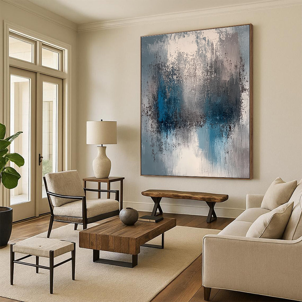 A large abstract painting featuring a faded gray and blue color palette with soft lighting and neutral tones.STSC577
