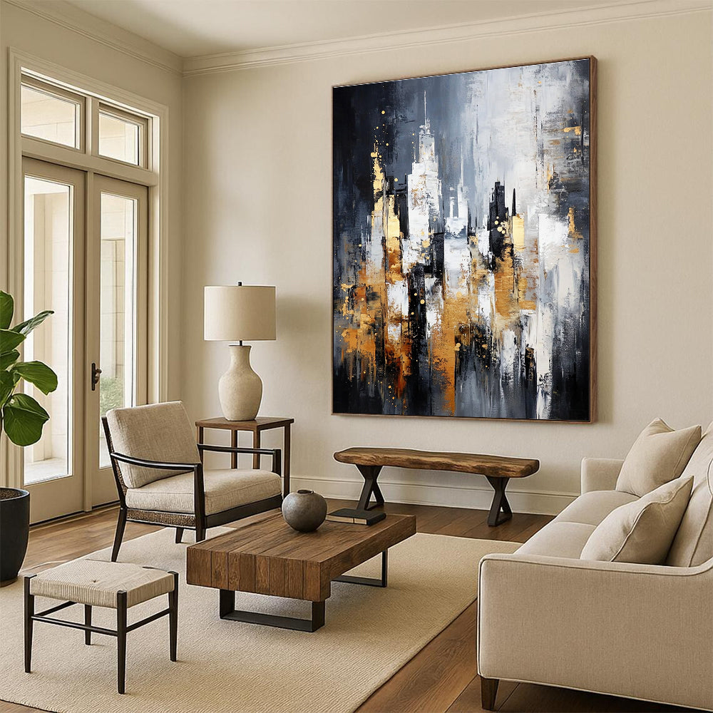 Large abstract painting of a cityscape in gray and white with gold accents on a dark background featuring neutral tones.STSC282