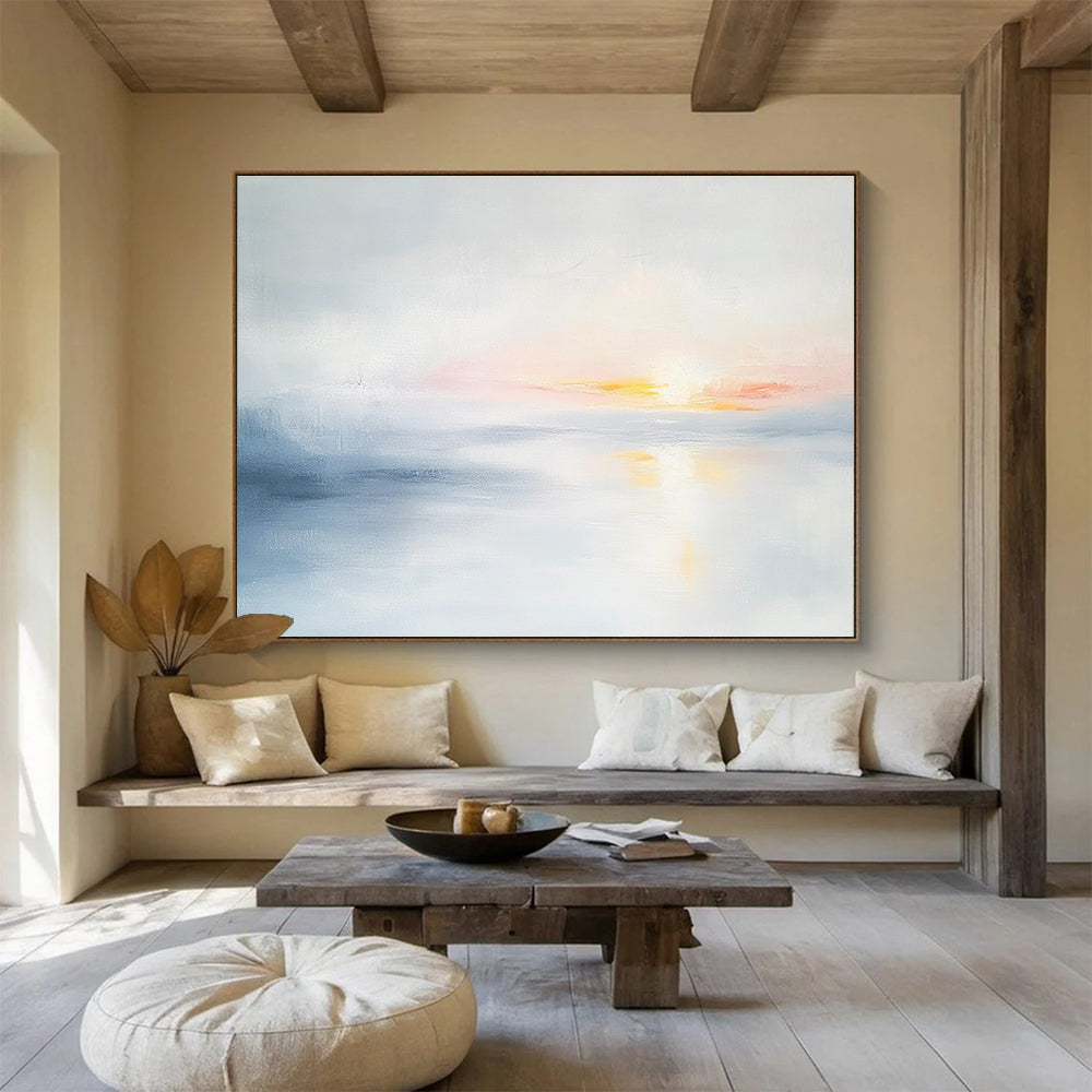 Large abstract painting featuring soft light sky blue and gray tones depicting a serene sunset over calm water on a white background.SC082